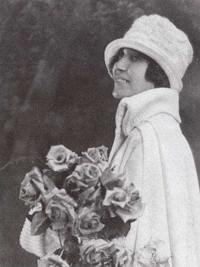 Un retrato de una joven Sonora Smart Dodd con rosas.