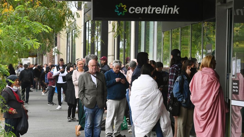Сотни людей выстраиваются в очередь перед австралийским государственным социальным центром Centrelink, Мельбурн