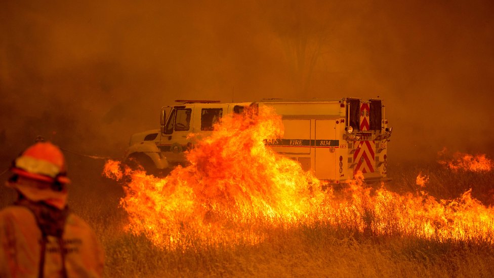 1 de julio: un vehículo de bomberos queda envuelto en llamas ante el paso de un incendio descontrolado que cruza la carretera cerca de Clearlake Oaks, en California el 1 de julio de 2018