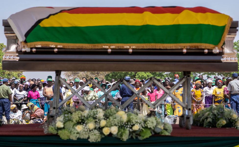 Мальчик проходит мимо цифрового изображения покойного бывшего президента Зимбабве Роберта Мугабе, когда его тело находится в штате в точке роста Муромбедзи, примерно в 107 км к северо-западу от Хараре, Зимбабве, 16 сентября 2019 г.