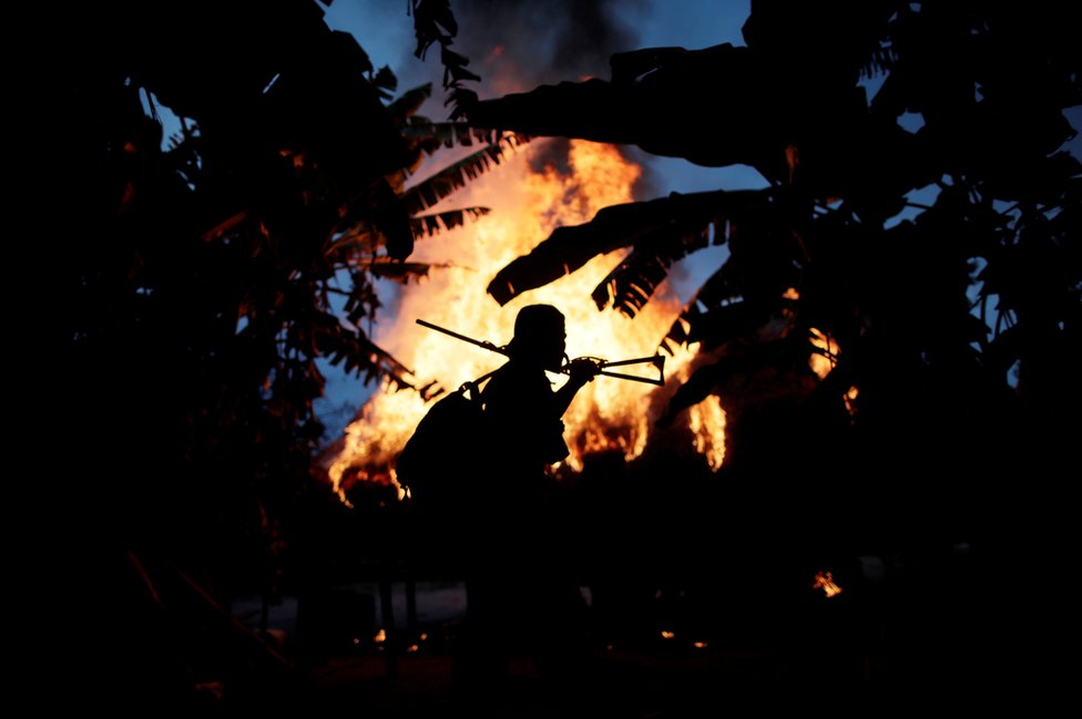 A man from the Guajajara community stands by a fire at a loggers camp
