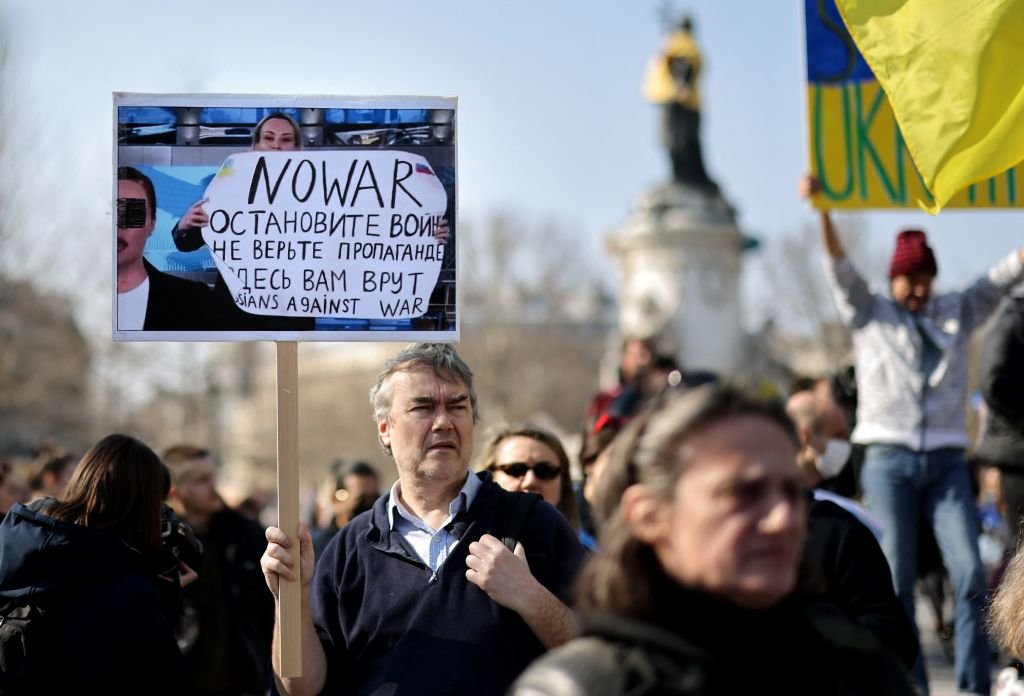 Un manifestante en París contra la guerra con la imagend e Marina Ovsyannikova.