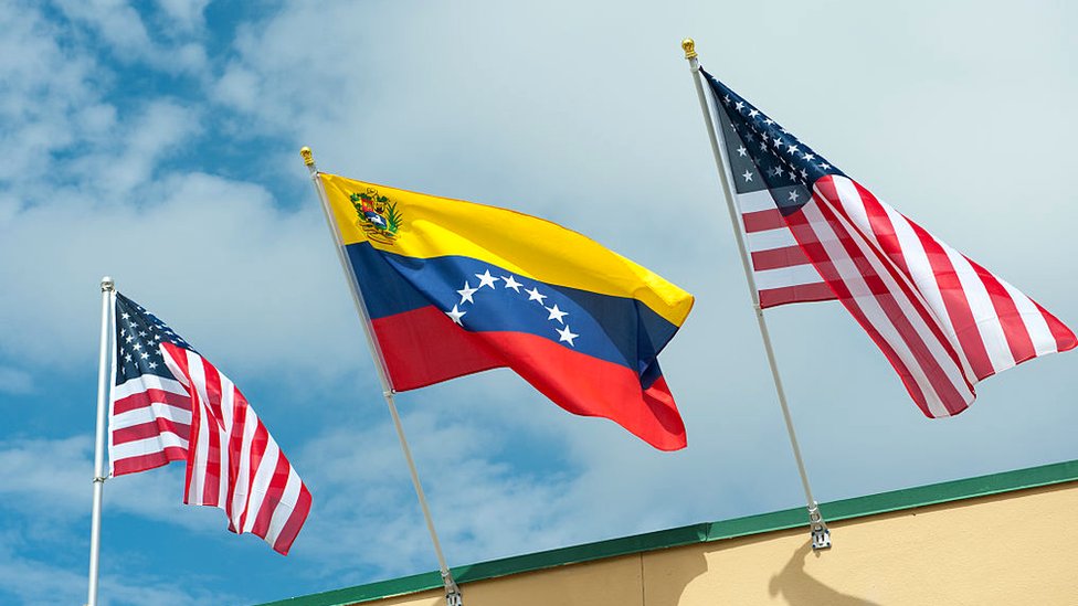 Bandera de Venezuela entre dos banderas de Estados Unidos.
