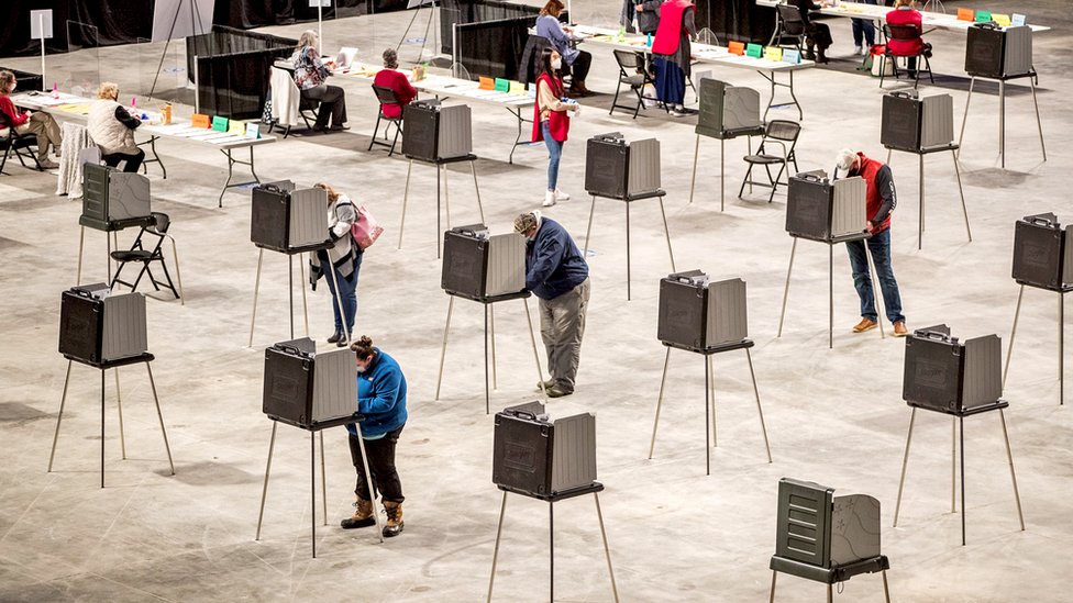 Voters cast their ballot in voting booths