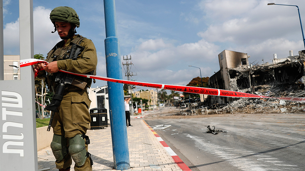An Israeli soldier closes the road leading to the destroyed police station that was controlled by Hamas militants in the southern city of Sderot, close to the Gaza border, Israel, 08 October 2023