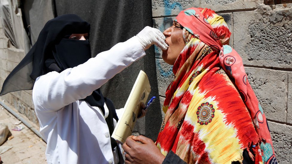 Una mujer vacuna a otra mujer mayor contra el cólera en Yemen en 2019