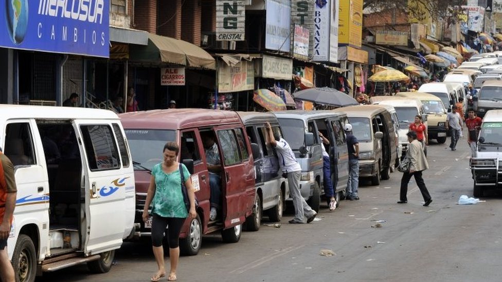 Microbuses privados esperan a los brasileños que van a comprar a Ciudad del Este, en Paraguay.