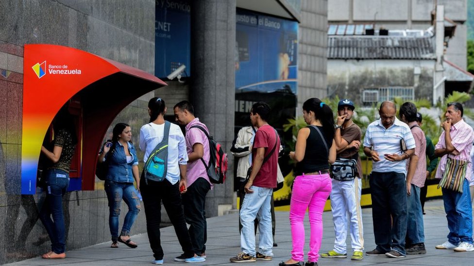 Una criptomoneda nacional podría ocasionar una crisis bancaria. Gente en un cajero