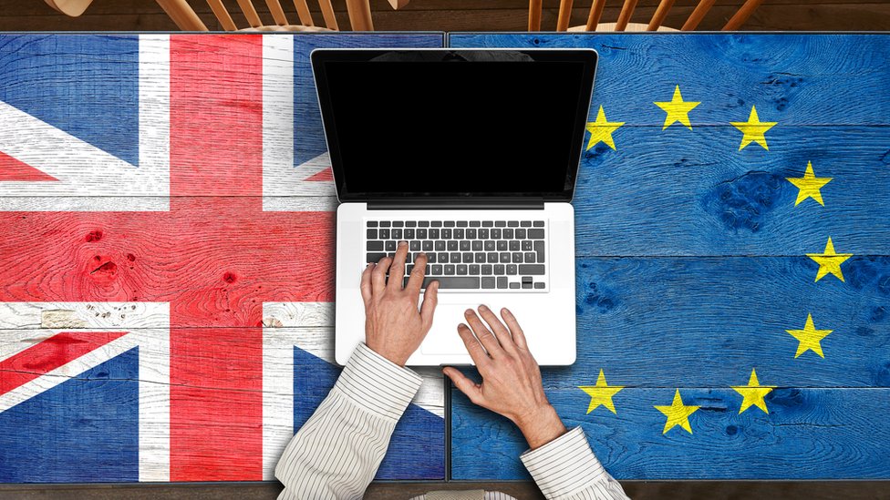 Laptop sobre banderas de Reino Unido y de la UE