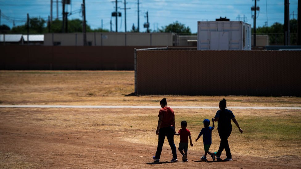 Dos madres caminan junto a sus hijos en el Centro Residencial Familiar del Sur de Texas en 2019.