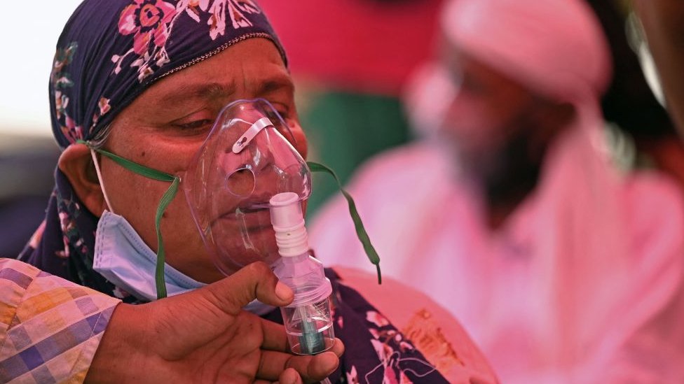 امرأة تحاول التنفس باستخدام أنبوب أكسجين