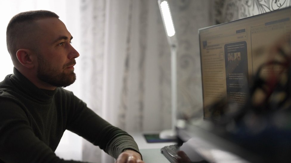 Oleksandr, sitting at his computer.