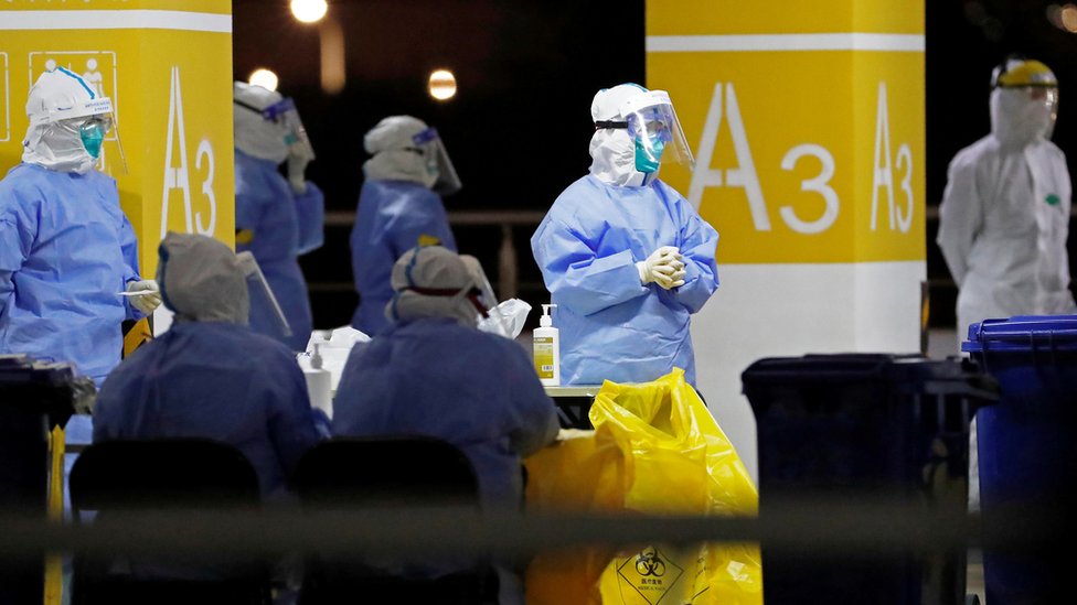 Workers in protective suits are seen at a makeshift nucleic acid testing site inside carpark at Shanghai Pudong International Airport