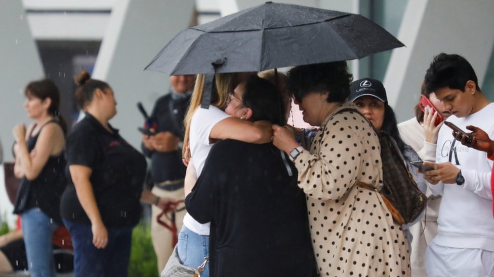 Personas se abrazan fuera del edificio derrumbado en Miami.
