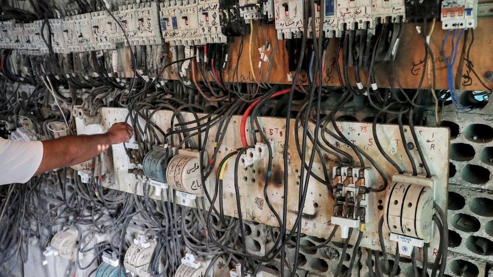 A technician connects wires at a power grid in Lebanon