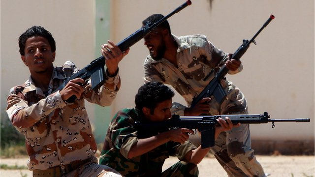 Libyan rebel forces carry guns as they train in the rebel stronghold of Benghazi.