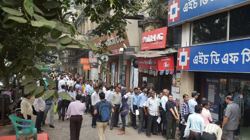 Люди стоят в очереди перед банком частного сектора во время общенациональной забастовки, которую основные профсоюзы призвали протестовать против демонетизации в Калькутте 28 ноября 2016 г.