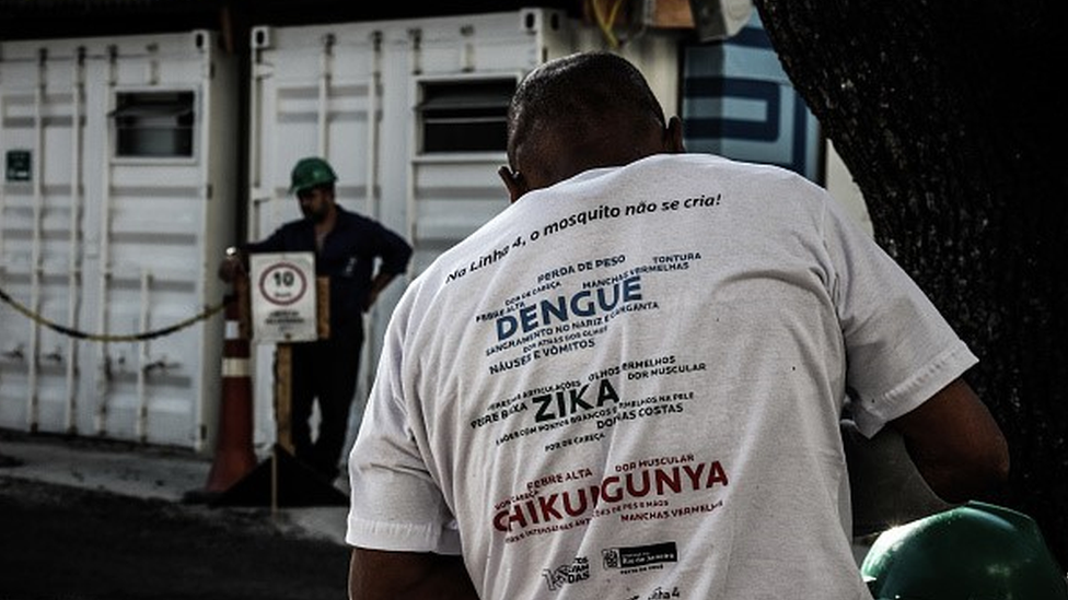 Agente comunitário da saúde com camiseta que traz informações sobre dengue, zika e chikungunya