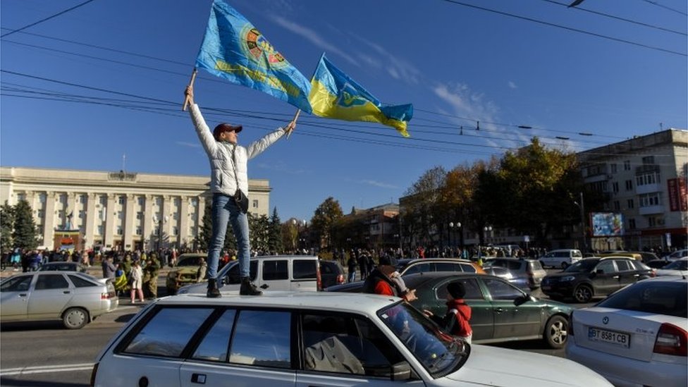 Un hombre ondea una bandera ucraniana en Jersón