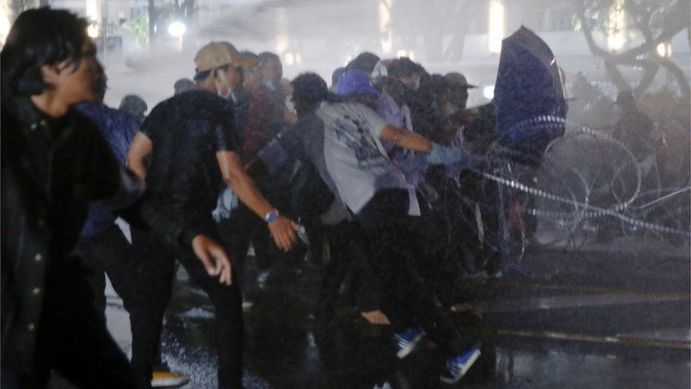 Протестующие бегут, поскольку полиция использует против них водометы в Бангкоке