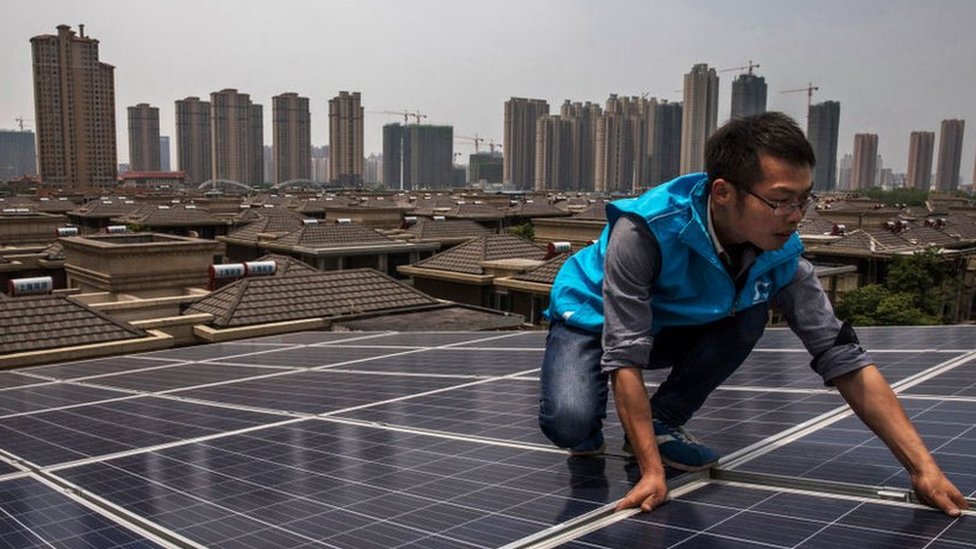 La industria de las energías renovables está creciendo y las empresas estadounidenses temen quedar rezagadas. Hombre colocando paneles solares en China.
