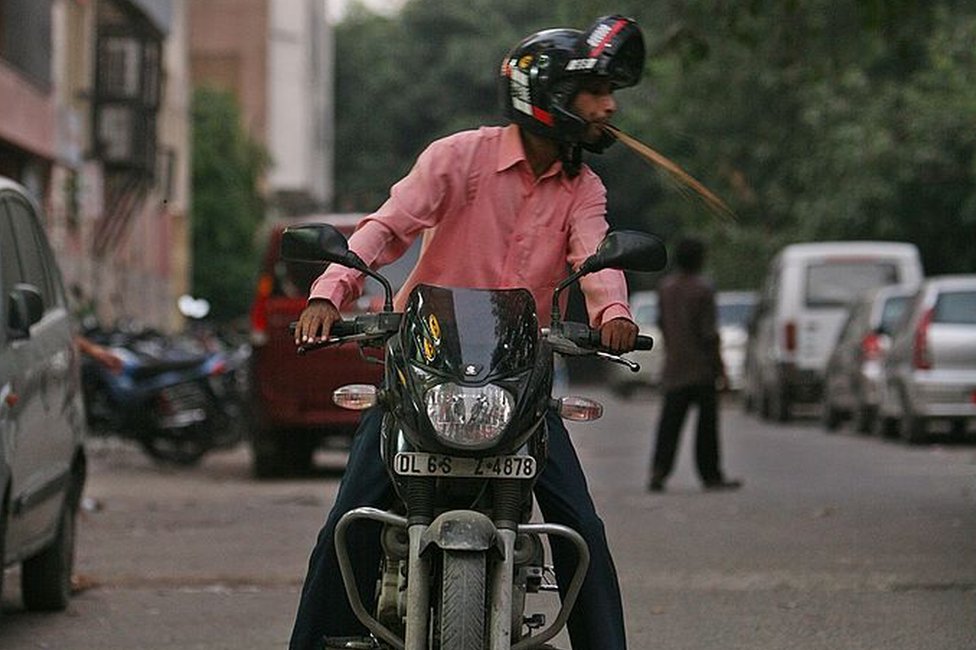 A motorist spits chewed betel nut on the raod with complete disregard towards cleanliness and aesthetics in New Delhi on September 29, 2009.