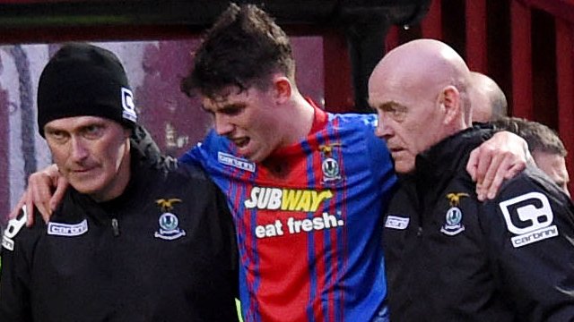 Inverness midfielder Ryan Christie is helped off the field following injury