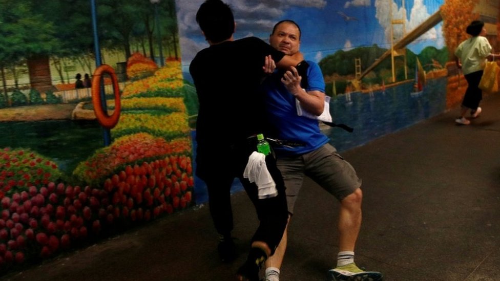 Сторонник проправительственных сил подвергается нападению со стороны сторонника борьбы с экстрадицией у офиса Джуниуса Хо в июле