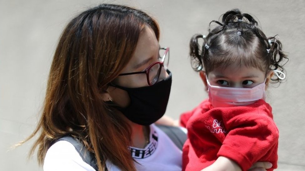 Женщина держит свою дочь возле больницы в Лос-Анджелес, Калифорния. Фото: июль 2020 г.