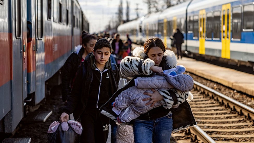 Família ucraniana em estação de trem na Romênia