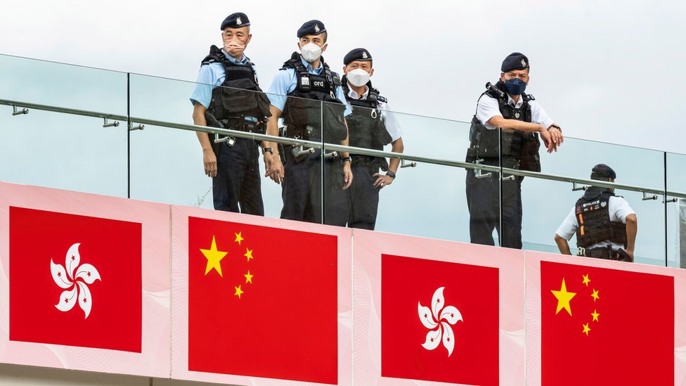 中國香港特區成立25週年日一群身穿防刺背心警員在九龍尖沙咀海旁高台上嚴密注視地面活動（1/7/2022）