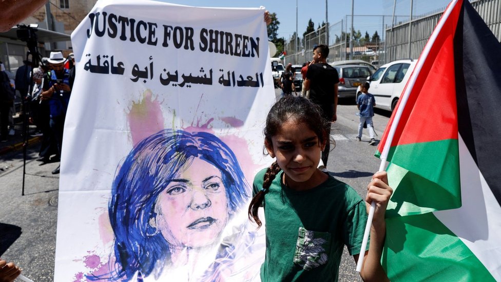 Foto de archivo mpostrando a una niña con un cartel exigiendo justicia por Shireen Abu Aqala