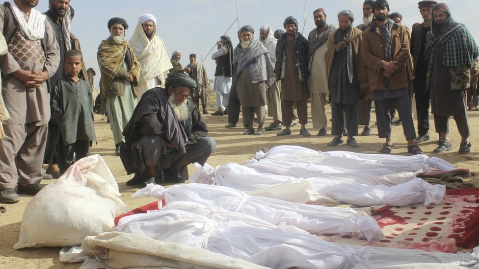 На этой фотографии от 4 ноября 2016 года афганские сельские жители собираются вокруг тел нескольких жертв, которые были убиты во время столкновений между талибами и афганскими силами безопасности в контролируемой талибами деревне Буз-и-Кандахари в провинции Кундуз, Афганистан