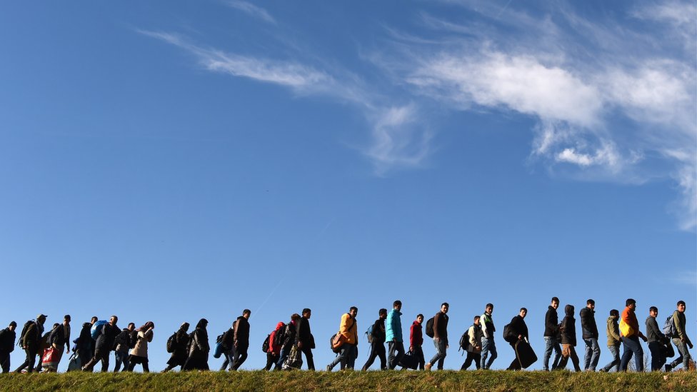 Migrants walk to a first registration point of the German federal police after they crossed the Austrian-German border in 2015