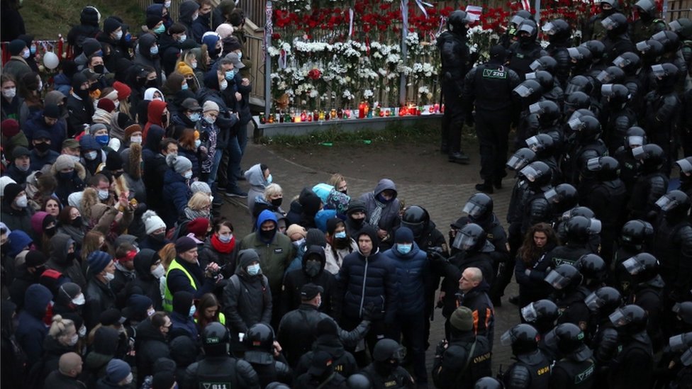 Belarussian policemen talk to protesters before detaining them during an anti-government rally in Minsk