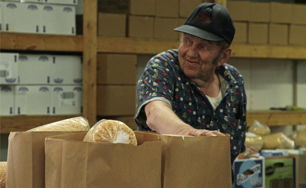 Un lugareño y cajas de alimentos en el banco de comida de Jamestown