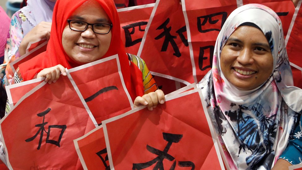 Учителя малайского языка в Куала-Лумпуре позируют на мероприятии по китайской каллиграфии, приуроченном к приближающемуся Году Свиньи