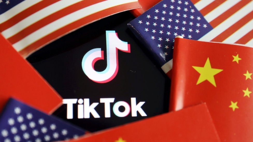 Флаги Китая и США вокруг логотипа TikTok.