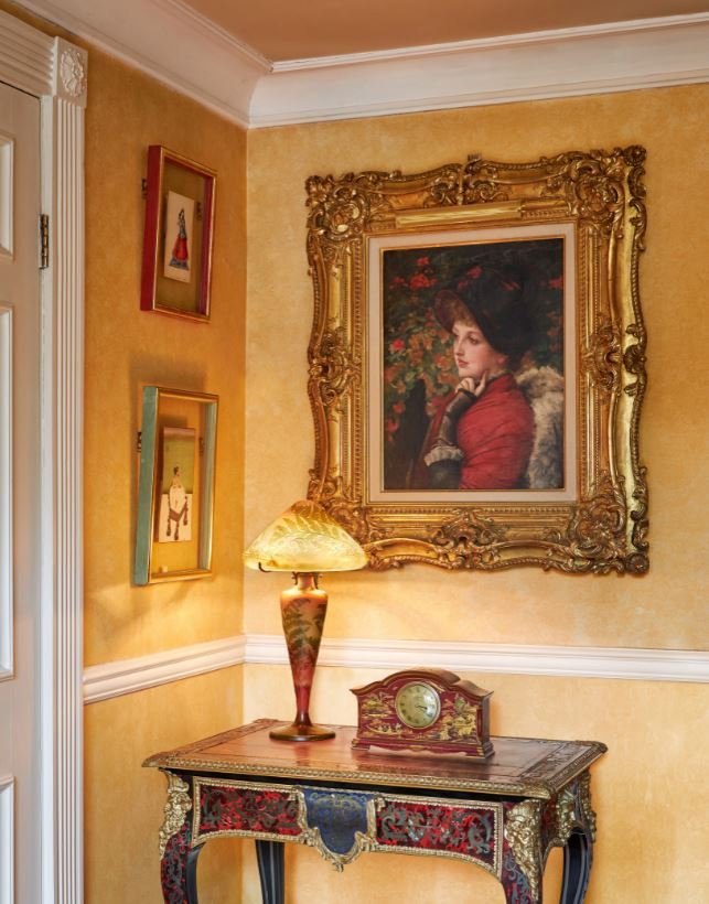 Un retrato de una mujer de James Jacques Tissot colgado en la pared amarilla del salón de Freddie Mercury