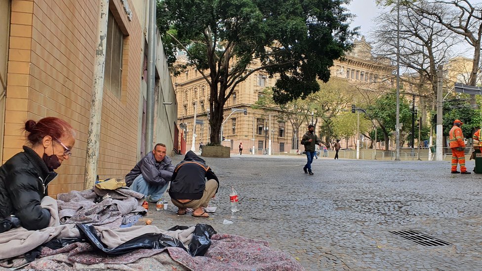 Irani Benedita de Araújo ao lado do marido (de frente) na calçada onde dormem na praça da Sé, no centro de São Paulo