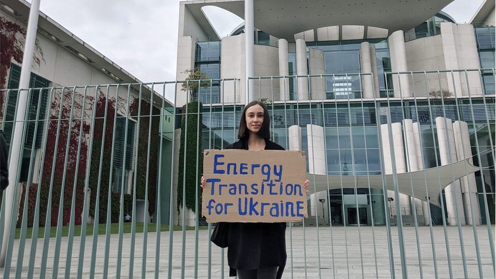 Natalia Lytvyn, a coordinator for the Energy Transition Coalition, holding a banned reading 'Energy transition for Ukraine" in Berlin, Germany, 2021