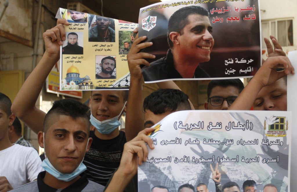 فلسطينيون يحملون صورة لزكريا الزبيدي قائد كتائب الاقصى في الضفة الغربية