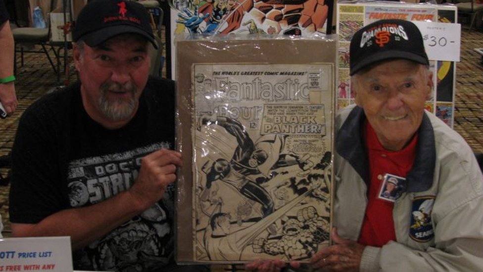 Джо Синнотт (справа) и его сын Марк держат оригинальную неиспользованную обложку Fantastic Four # 52, первое появление Черной пантеры на Albany Comic Con, 2016