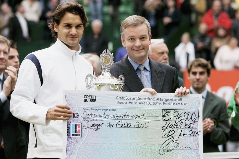 Roger Federer recibe un cheque de Credit Suisse tras ganar un torneo de tenis en 2005 en Alemania.