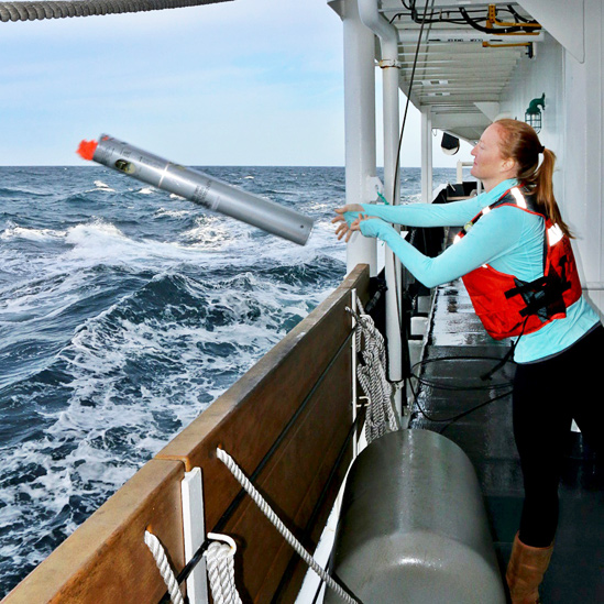Jessica Crance a bordo de una embarcación lanzando una sonoboya al mar