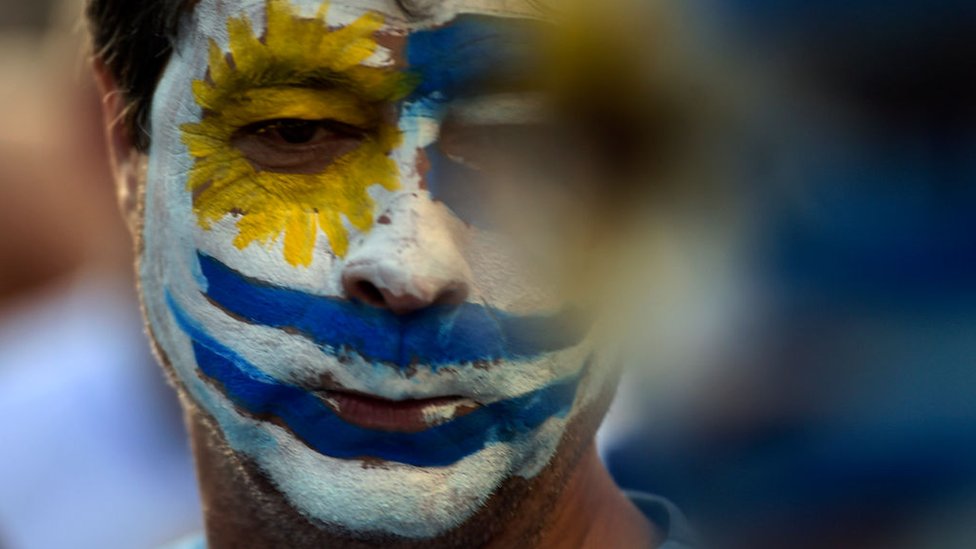 Hombre con la bandera de Uruguay pintada en la cara.