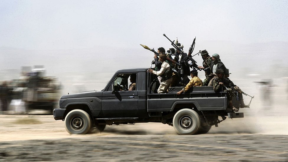 un grupo de hutíes armados en un vehículo.
