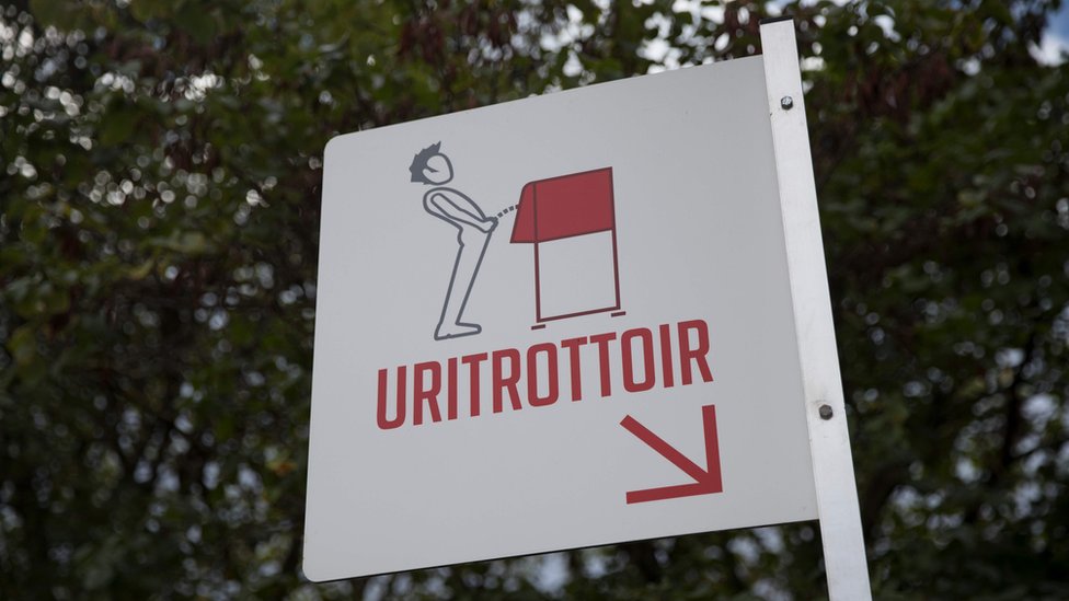 Un cartel señala los urinales públicos.