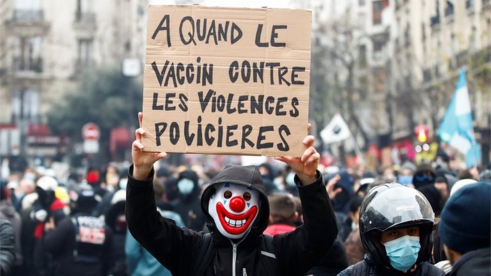 A demonstrator holds a placard reading "When will there be a vaccine against police violence" during a demonstration in front of a hospital in Paris, France, on 5 December 2020