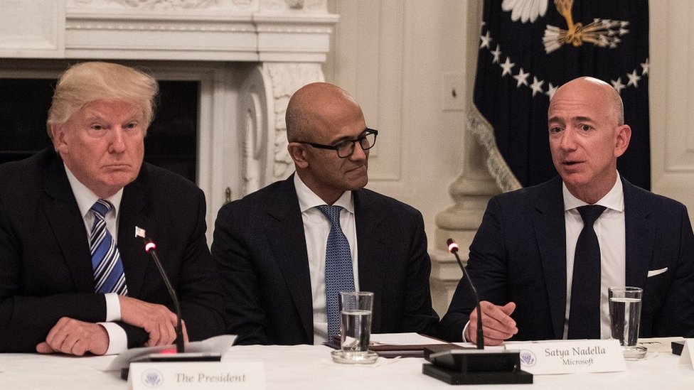 US President Donald Trump (L) and Microsoft CEO Satya Nadella (C) listen to Amazon CEO Jeff Bezos (R) during an American Technology Council roundtable at the White House in Washington, DC, on June 19, 2017.